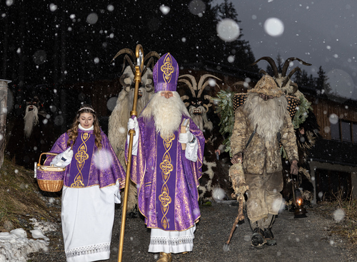 Heiliger Nikolaus mit einem Engel und Perchten. Brauchtum in Österreich. 